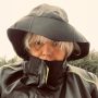 Eine Frau desren Gesicht fast vollständig von einer Regenjacke bedeckt ist